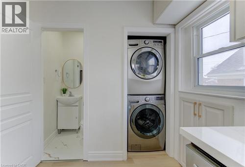 Laundry area featuring stacked washer and dryer and light wood-style floors - 171 Sixth Avenue, Kitchener, ON - Indoor Photo Showing Laundry Room