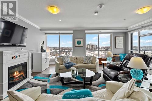 Living/dining - NW facing - 411 - 260 Villagewalk Boulevard, London North (North R), ON - Indoor Photo Showing Living Room With Fireplace