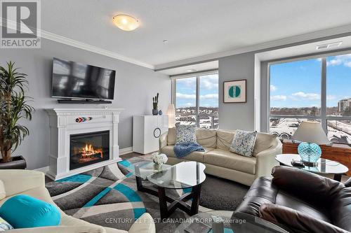 Living/dining - NW facing - 411 - 260 Villagewalk Boulevard, London North (North R), ON - Indoor Photo Showing Living Room With Fireplace
