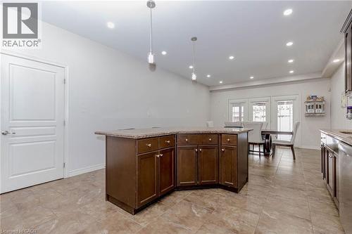 Kitchen featuring a center island, dark wood finish cabinets, and light stone countertops - 2 Doon Creek Street, Kitchener, ON - Indoor Photo Showing Kitchen
