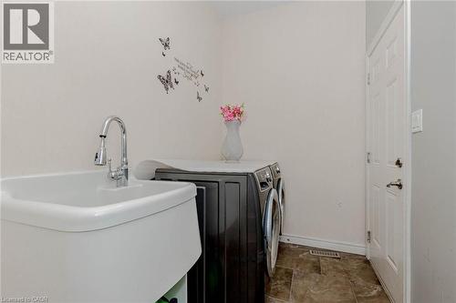 Laundry room with separate washer and dryer and dark stone finish flooring - 2 Doon Creek Street, Kitchener, ON - Indoor Photo Showing Laundry Room