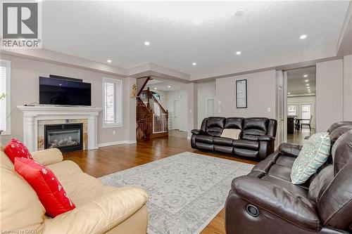 Living room with light wood-style floors and a high end fireplace - 2 Doon Creek Street, Kitchener, ON - Indoor Photo Showing Living Room With Fireplace