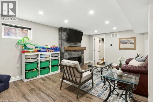 Living room with a fireplace, wood finished floors, and recessed lighting - 237 East 32Nd Street, Hamilton, ON - Indoor With Fireplace