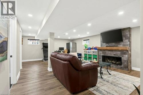 Living room with a fireplace, wood finished floors, and recessed lighting - 237 East 32Nd Street, Hamilton, ON - Indoor With Fireplace