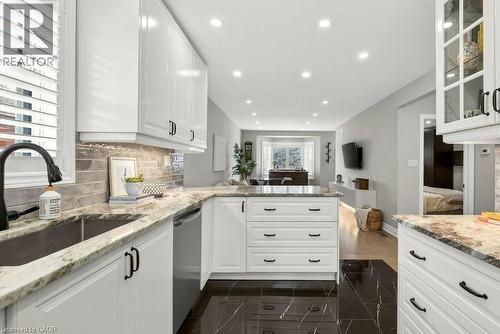 Kitchen with light stone counters, white cabinetry, a peninsula, stainless steel dishwasher, and recessed lighting - 237 East 32Nd Street, Hamilton, ON - Indoor Photo Showing Kitchen With Upgraded Kitchen