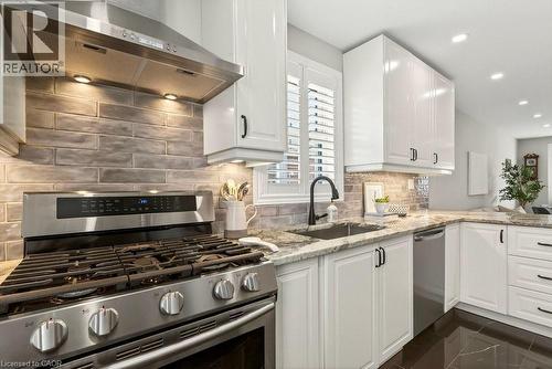 Kitchen featuring stainless steel appliances, light stone countertops, white cabinets, recessed lighting, and decorative backsplash - 237 East 32Nd Street, Hamilton, ON - Indoor Photo Showing Kitchen With Upgraded Kitchen
