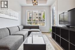 Living room with light wood finished floors and a raised ceiling - 