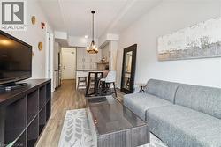 Living area featuring light wood-style flooring, a chandelier, and arched walkways - 