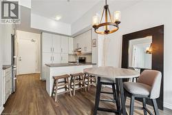 Dining room with dark wood-type flooring and hanging lights - 
