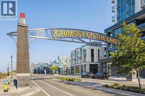 View of asphalt road with sidewalks, curbs, and street lights - 40 Esplanade Lane Unit# 102, Grimsby, ON - Outdoor