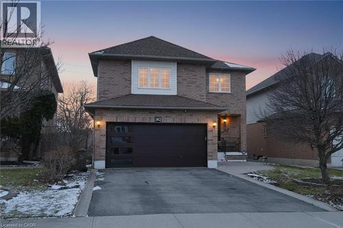 Traditional-style home featuring driveway, brick siding, an attached garage, and a shingled roof - 142 Hawkswood Trail, Hamilton, ON - Outdoor