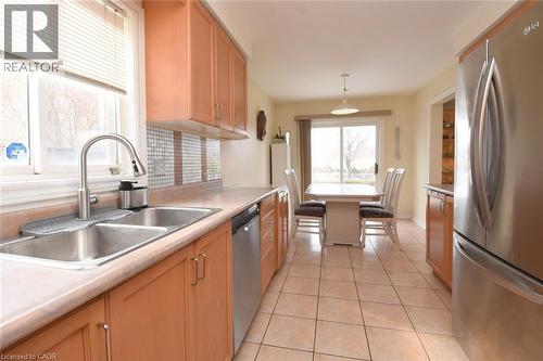 Kitchen with stainless steel appliances, light tile patterned floors, light countertops, and pendant lighting - 142 Hawkswood Trail, Hamilton, ON - Indoor Photo Showing Kitchen With Double Sink
