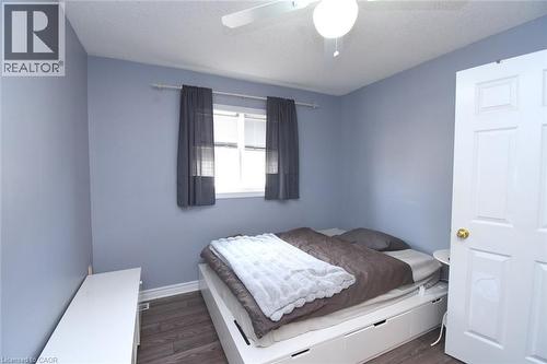 Bedroom featuring dark wood finished floors, a textured ceiling, and ceiling fan - 142 Hawkswood Trail, Hamilton, ON - Indoor Photo Showing Bedroom