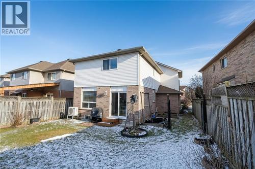 Snow covered property with entry steps, a fenced backyard, and brick siding - 142 Hawkswood Trail, Hamilton, ON - Outdoor