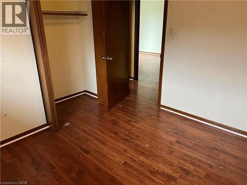 Unfurnished bedroom featuring dark wood finished floors and a closet - 185 Lavina Crescent, Hamilton, ON - Indoor Photo Showing Other Room