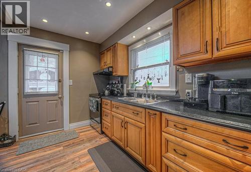 Kitchen featuring wood finish cabinets, stainless steel electric stove, recessed lighting, light wood-style flooring, and dark stone counters - 81 Beechwood Avenue, Hamilton, ON - Indoor Photo Showing Kitchen With Double Sink