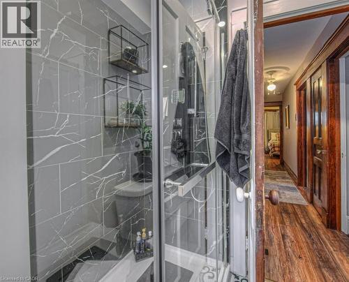 Bathroom with a marble finish shower and hardwood / wood-style floors - 81 Beechwood Avenue, Hamilton, ON - Indoor