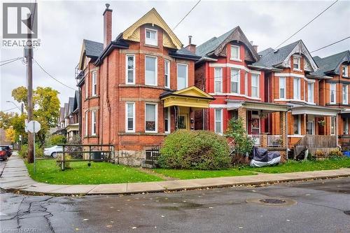 Victorian house with a chimney, brick siding, and covered porch - 44 Ashley Street, Hamilton, ON - Outdoor With Facade
