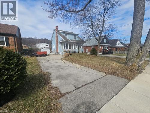 Bungalow-style house featuring a chimney, asphalt driveway, and a front yard - 170 Stewartdale Avenue, Hamilton, ON - Outdoor