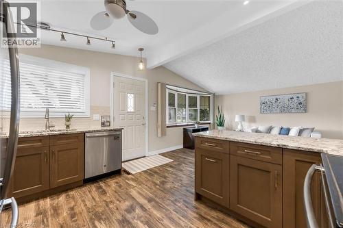 Kitchen with light stone counters, stainless steel appliances, dark wood-style flooring, ceiling fan, and tasteful backsplash - 77 Lawfield Drive, Hamilton, ON - Indoor Photo Showing Kitchen