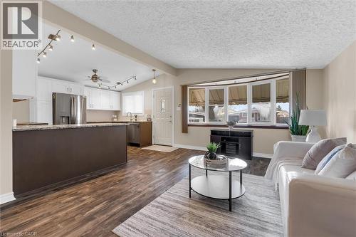 Living area with ceiling fan, dark wood-style flooring, a textured ceiling, and beamed ceiling - 77 Lawfield Drive, Hamilton, ON - Indoor Photo Showing Living Room