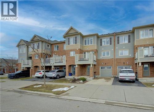 View of front of property featuring driveway, brick siding, a balcony, and an attached garage - 9 Outlook Terrace, Kitchener, ON - Outdoor With Balcony With Facade