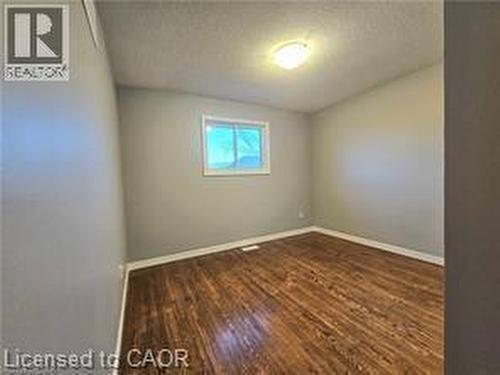 Spare room with dark wood-type flooring and baseboards - 486 Dicenzo Drive, Hamilton, ON - Indoor Photo Showing Other Room