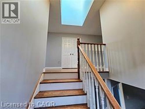 Stairway with a skylight and wood finished floors - 486 Dicenzo Drive, Hamilton, ON - Indoor Photo Showing Other Room