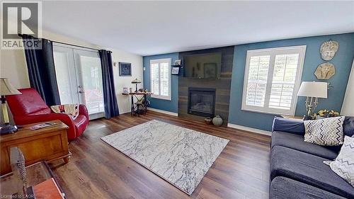 Living area featuring dark wood-style floors and a large fireplace - 27 Hepburn Avenue, St. Thomas, ON - Indoor Photo Showing Living Room With Fireplace