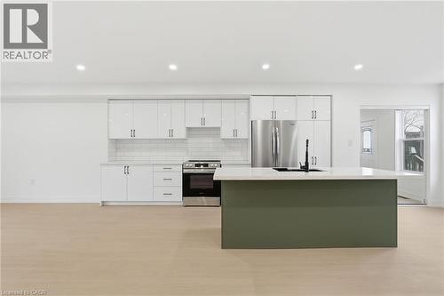 Dual tone kitchen featuring stainless steel appliances, a center island with sink, backsplash, recessed lighting, and light stone countertops - 1278 Main Street E, Hamilton, ON - Indoor Photo Showing Kitchen With Stainless Steel Kitchen With Upgraded Kitchen