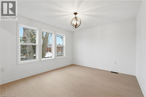 Empty room featuring hanging lights and light wood finished floors - 1278 Main Street E, Hamilton, ON - Indoor Photo Showing Other Room