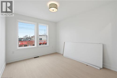 Unfurnished room with light wood-type flooring and radiator - 1278 Main Street E, Hamilton, ON - Indoor Photo Showing Other Room