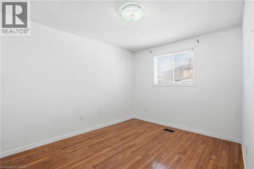 Unfurnished room featuring hardwood / wood-style floors and a textured ceiling - 513 Rexford Drive, Hamilton, ON - Indoor Photo Showing Other Room