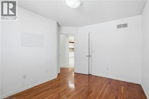 Spare room with wood-type flooring and a textured ceiling - 513 Rexford Drive, Hamilton, ON - Indoor Photo Showing Other Room
