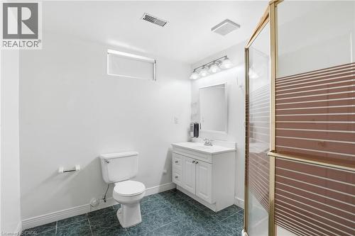 Bathroom with a stall shower, vanity, and dark tile patterned flooring - 513 Rexford Drive, Hamilton, ON - Indoor Photo Showing Bathroom