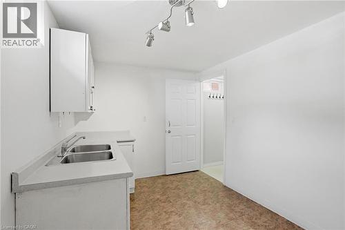 Kitchen featuring white cabinetry, light countertops, and rail lighting - 513 Rexford Drive, Hamilton, ON - Indoor