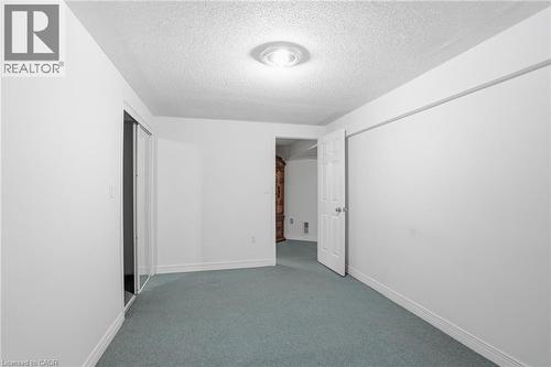 Spare room with carpet flooring and a textured ceiling - 513 Rexford Drive, Hamilton, ON - Indoor Photo Showing Other Room