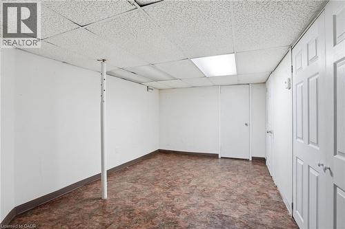Finished basement with a paneled ceiling and dark flooring - 513 Rexford Drive, Hamilton, ON - Indoor Photo Showing Other Room