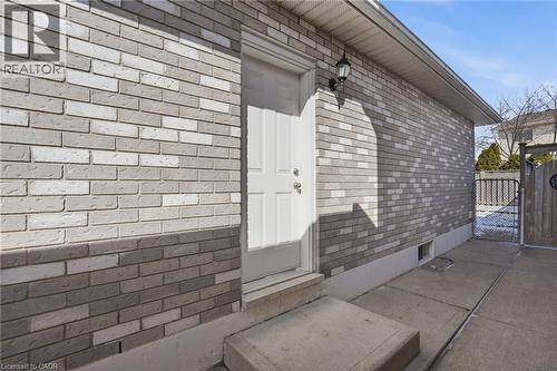 Entrance to property with a gate and brick siding - 513 Rexford Drive, Hamilton, ON - Outdoor With Exterior
