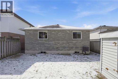 Snow covered property featuring brick siding and a fenced backyard - 513 Rexford Drive, Hamilton, ON - Outdoor With Exterior