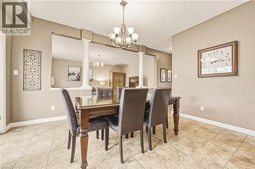 Dining space with a chandelier, ornate columns, and light tile patterned floors - 120 Valiant Circle, Hamilton, ON - Indoor Photo Showing Dining Room