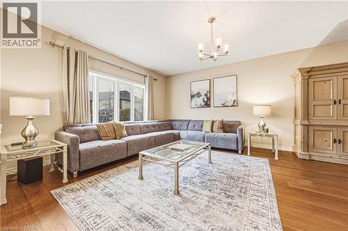 Living area featuring suspended lighting and wood finished floors - 120 Valiant Circle, Hamilton, ON - Indoor Photo Showing Living Room