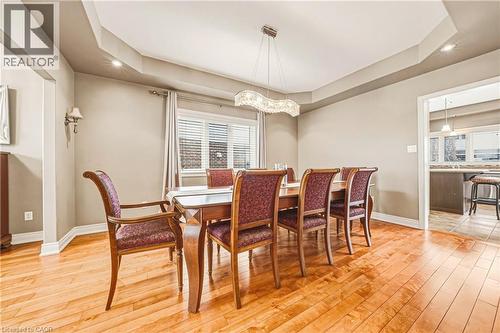 Dining area featuring a raised ceiling, light wood-style floors, and a chandelier - 120 Valiant Circle, Hamilton, ON - Indoor Photo Showing Dining Room
