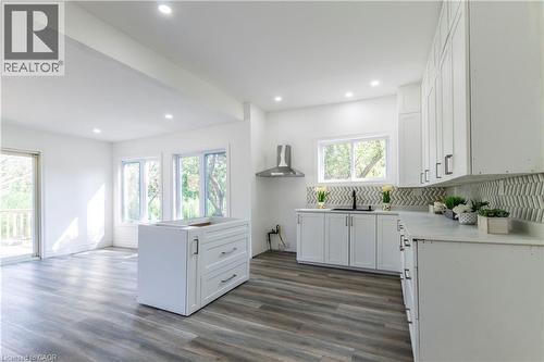 Kitchen featuring white cabinetry, light countertops, dark wood-style flooring, a kitchen island, and recessed lighting - 1411 E 56 Highway, Glanbrook, ON - Indoor Photo Showing Kitchen