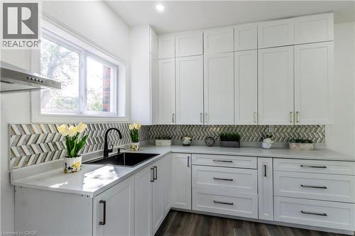 Kitchen featuring white cabinetry, ventilation hood, dark wood-style flooring, tasteful backsplash, and recessed lighting - 1411 E 56 Highway, Glanbrook, ON - Indoor Photo Showing Kitchen