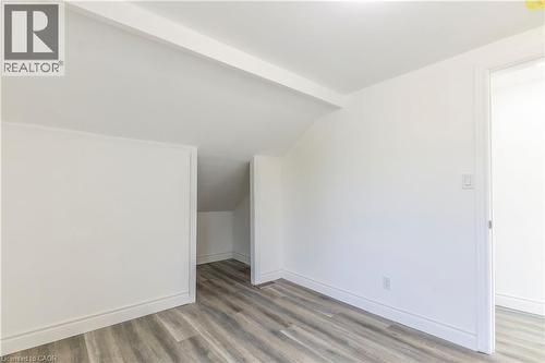 Additional living space with light wood-style flooring and vaulted ceiling with beams - 1411 E 56 Highway, Glanbrook, ON - Indoor Photo Showing Other Room