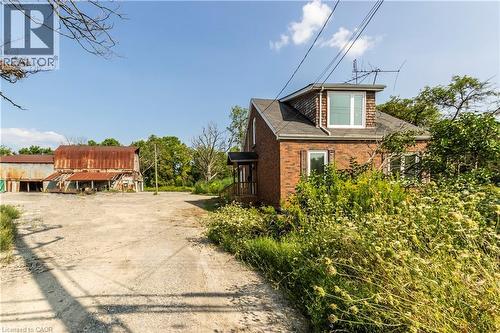 View of property exterior with brick siding, driveway, and roof with shingles - 1411 E 56 Highway, Glanbrook, ON - Outdoor
