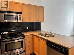 Kitchen with stainless steel appliances, a peninsula, light stone countertops, and decorative backsplash - 