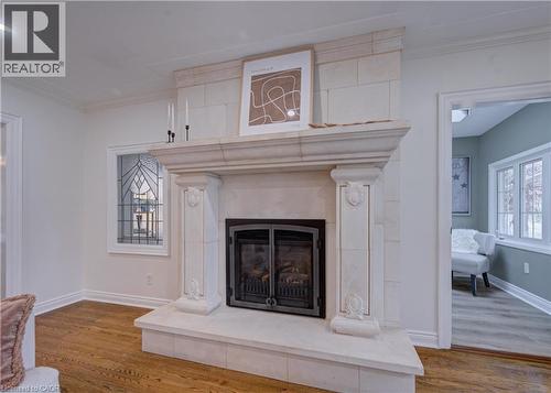 Detailed view of ornamental molding, a fireplace with raised hearth, and wood finished floors - 655 Ellengale Road, Burlington, ON - Indoor With Fireplace