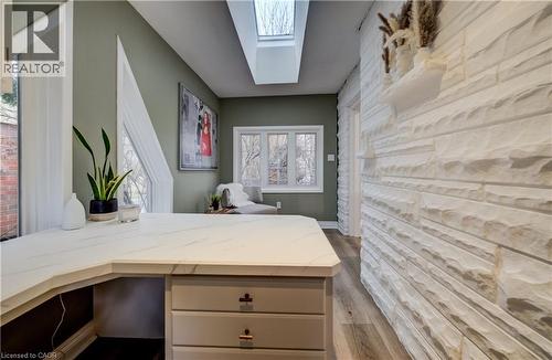 Home office featuring a skylight, dark wood-style flooring, and an accent wall - 655 Ellengale Road, Burlington, ON - Indoor